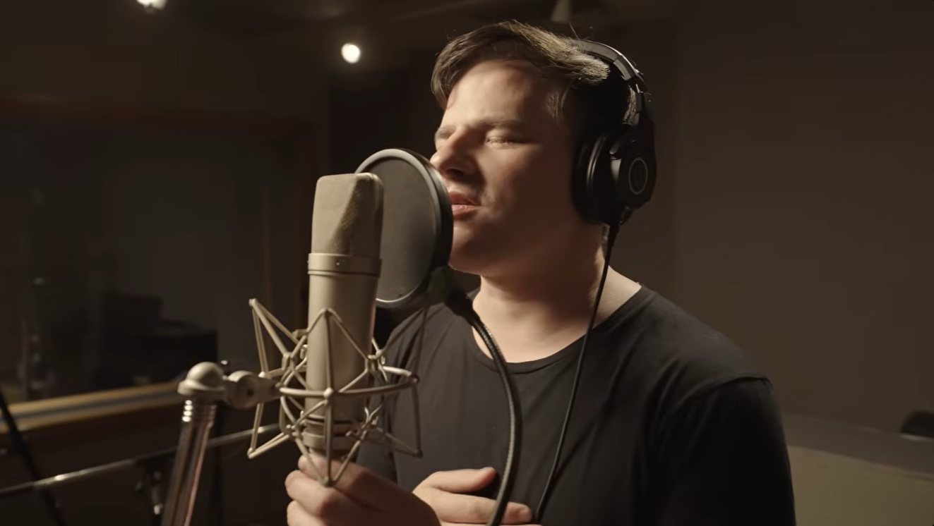Nahuel Pennisi singing at a studio microphone with A 18 Minutos in the video of Spinetta&rsquo;s Canción para los días de la vida
